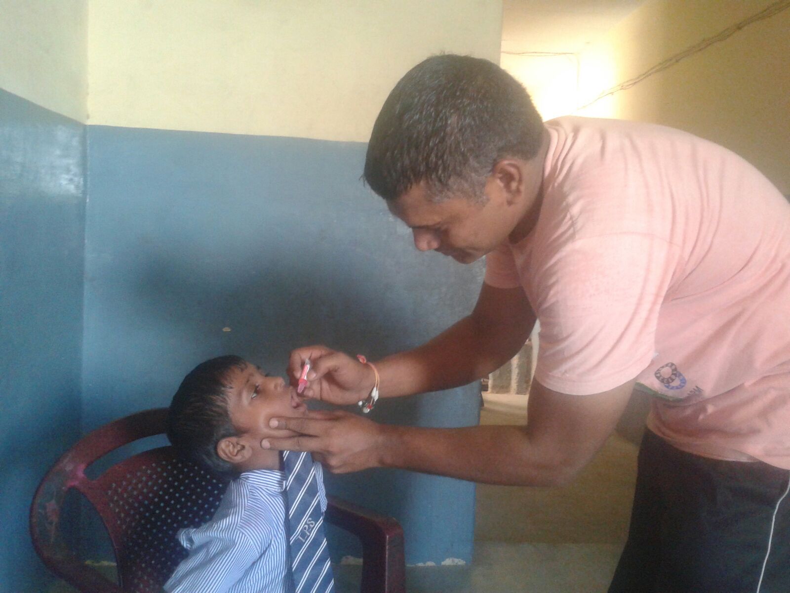 Mohit is 5 years old. He is receiving oral vaccines in this photo. 