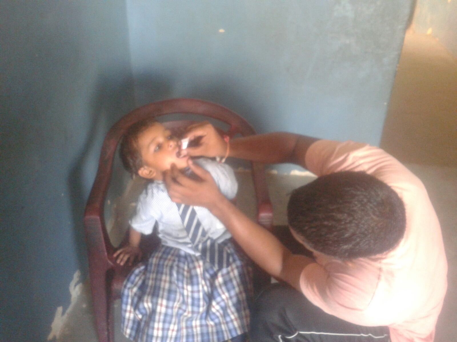 This is Dinar. He is 3 years old. He wants to be a doctor when he grows up. He is receiving oral vaccines in this picture.