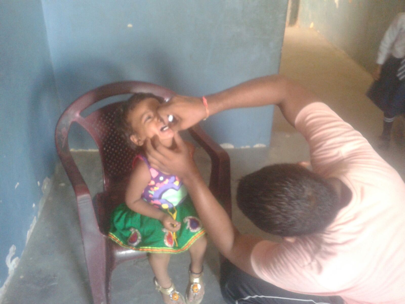 This is Krithika. She was not very happy about receiving oral vaccines, as you can tell in this picture. We spoke with her parents, who wanted us to provide her vaccines. 