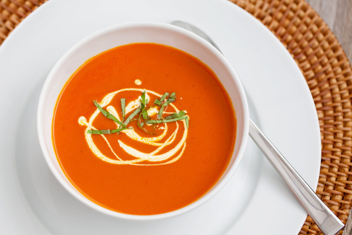 Roasted Red Pepper & Tomato Soup is a vibrant red colour - serve with a drizzle of cream and some shredded fresh basil leaves for a simple but impressive garnish.
