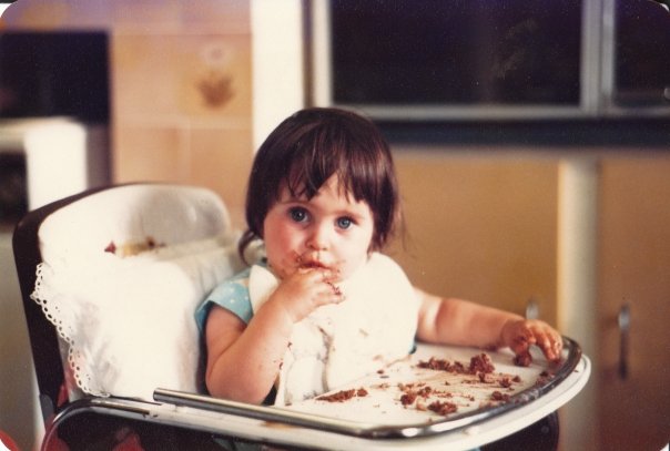 Sarah on her 1st birthday, fully immersed in her first chocolate cake experience. 