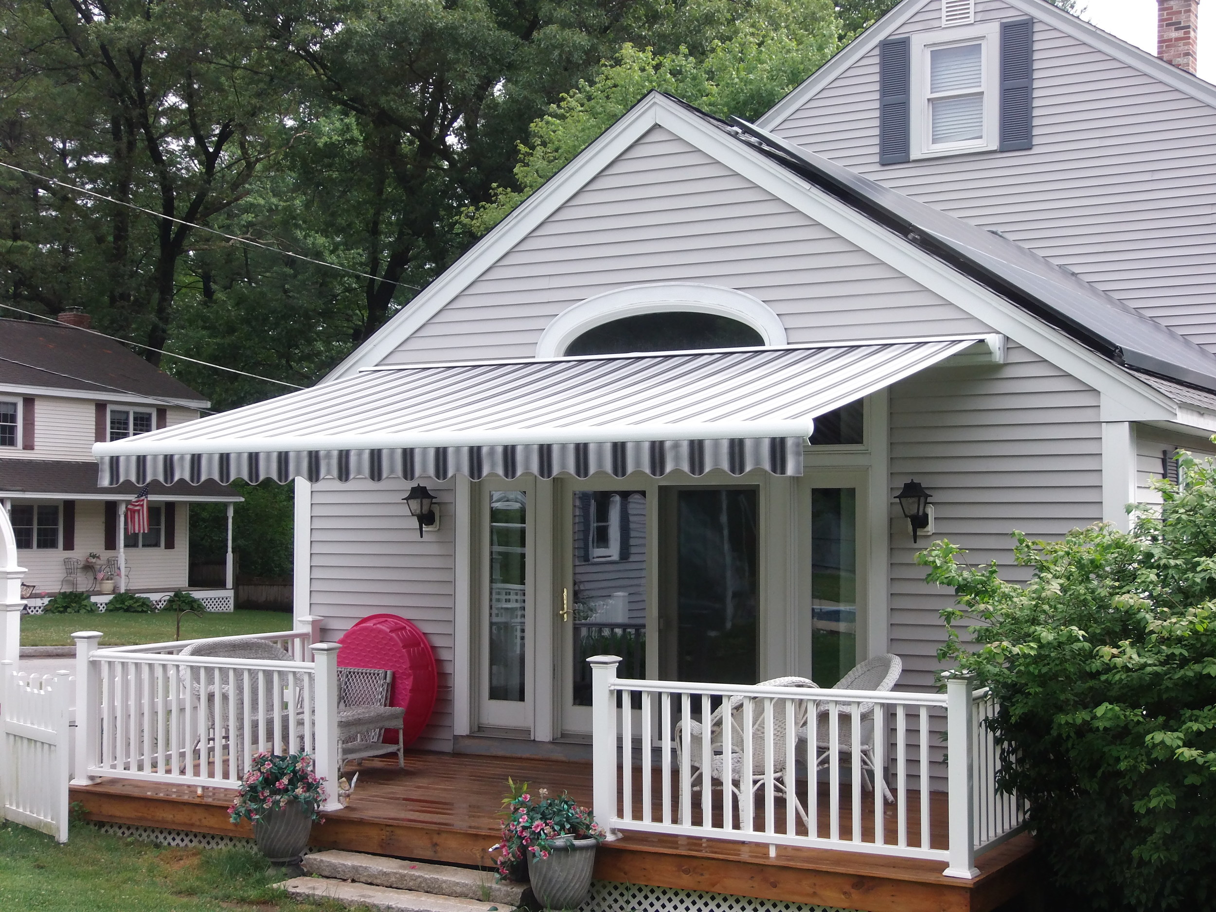 Retractable awning offering shade and style. Installed by Betterliving Sunrooms of NH in Chelmsford, MA.