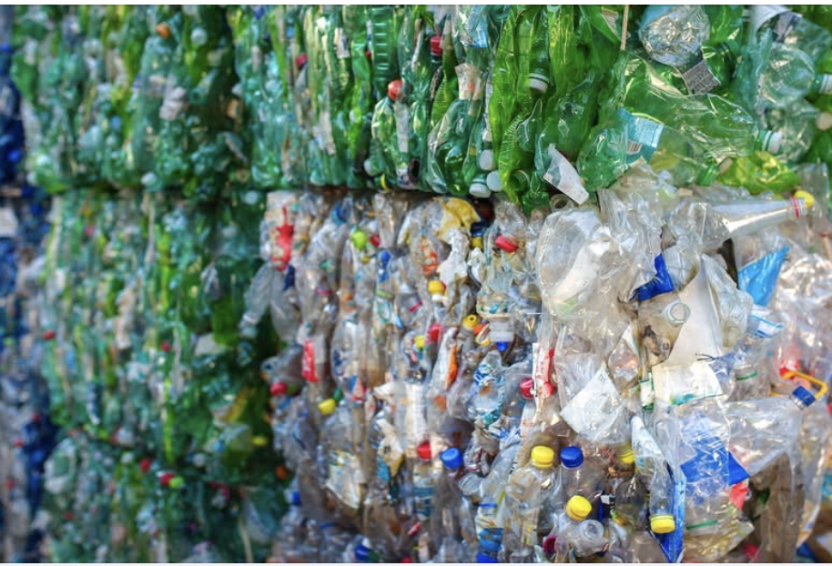A wall of crushed single-used plastic items such as beads and bottles