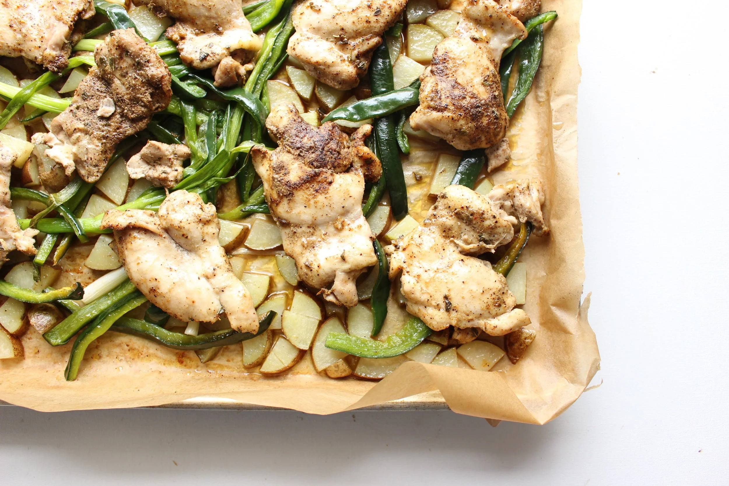 Sheet pan dinner: chicken thighs with poblano peppers, potatoes, and scallions.