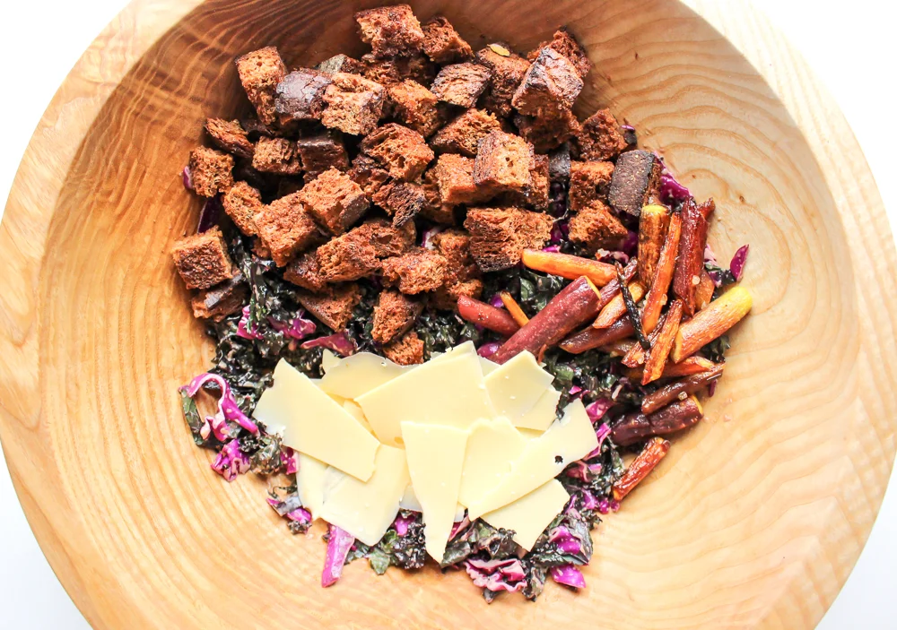 Purple kale and cabbage salad | Me & The Moose. A simple winter salad with greens, cabbage, roasted vegetables, and garlicky pumpernickel croutons tossed with a shallot vinaigrette is as filling and cozy as a salad can be. #meandthemoose #salad #wintersalad #saladrecipes #vegetarian #kale #cabbage #purplefoods