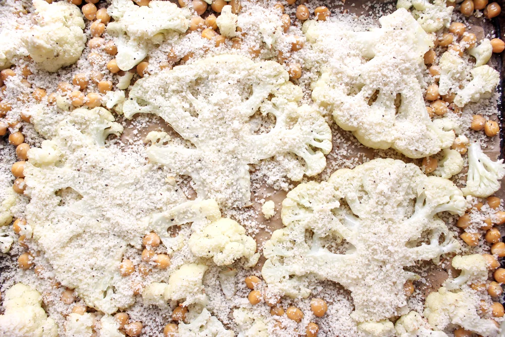 Cacio e pepe cauliflower and chickpeas | Me & The Moose. This vegetarian sheetpan dish hits all the right notes of cheesy, creamy, crunchy, and delicious. It’s filled with protein and appealing to vegetarians and carnivores alike. #meandthemoose #sheetpanmeals #vegetarianrecipes #cauliflower #cheese #cacioepepe #chickpeas #vegetarian #vegetariandinners