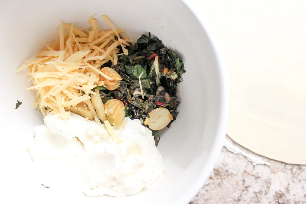 Rainbow Chard Galette | Me & The Moose. This galette is a super-easy show stopper for Easter and beyond! we ate it for dinner last night and the preschooler didn’t bat an eye at the heaps of greens. #meandthemoose #rainbowchard #sidedishes #vegetarian #vegetarianrecipes #rainbowchardrecipes #farmersmarketrecipes #easterrecipes #easterbrunchrecipes #easterdinnerrecipes