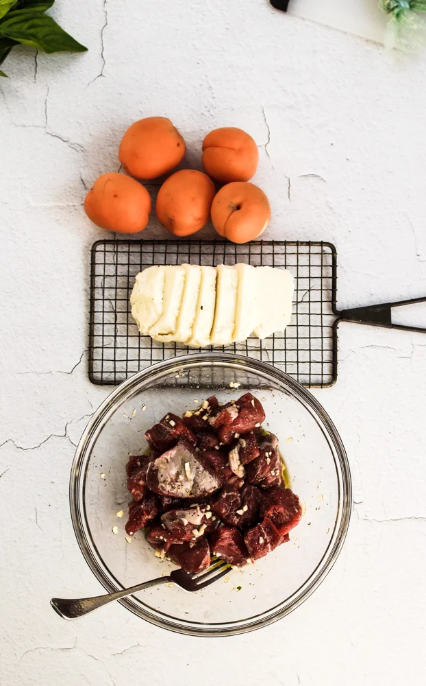 Grilled lamb kebabs with haloumi and apricots | Me & The Moose. Shake up your grill routine with chunks of fatty, savory lamb; melty, salty haloumi cheese; and tart, sweet apricots. #meandthemoose #grilling #lamb #kebabs #haloumi #dinnerrecipes #kebabrecipes #mediterraneandiet #pesto