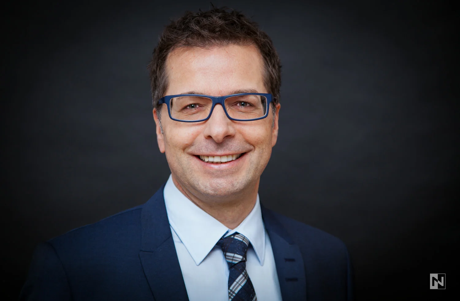 Studioportrait eines Managers vor schwarzem Hintergrund