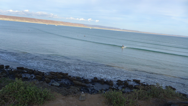 Erik surfing, with shrimp boats in the distance. 