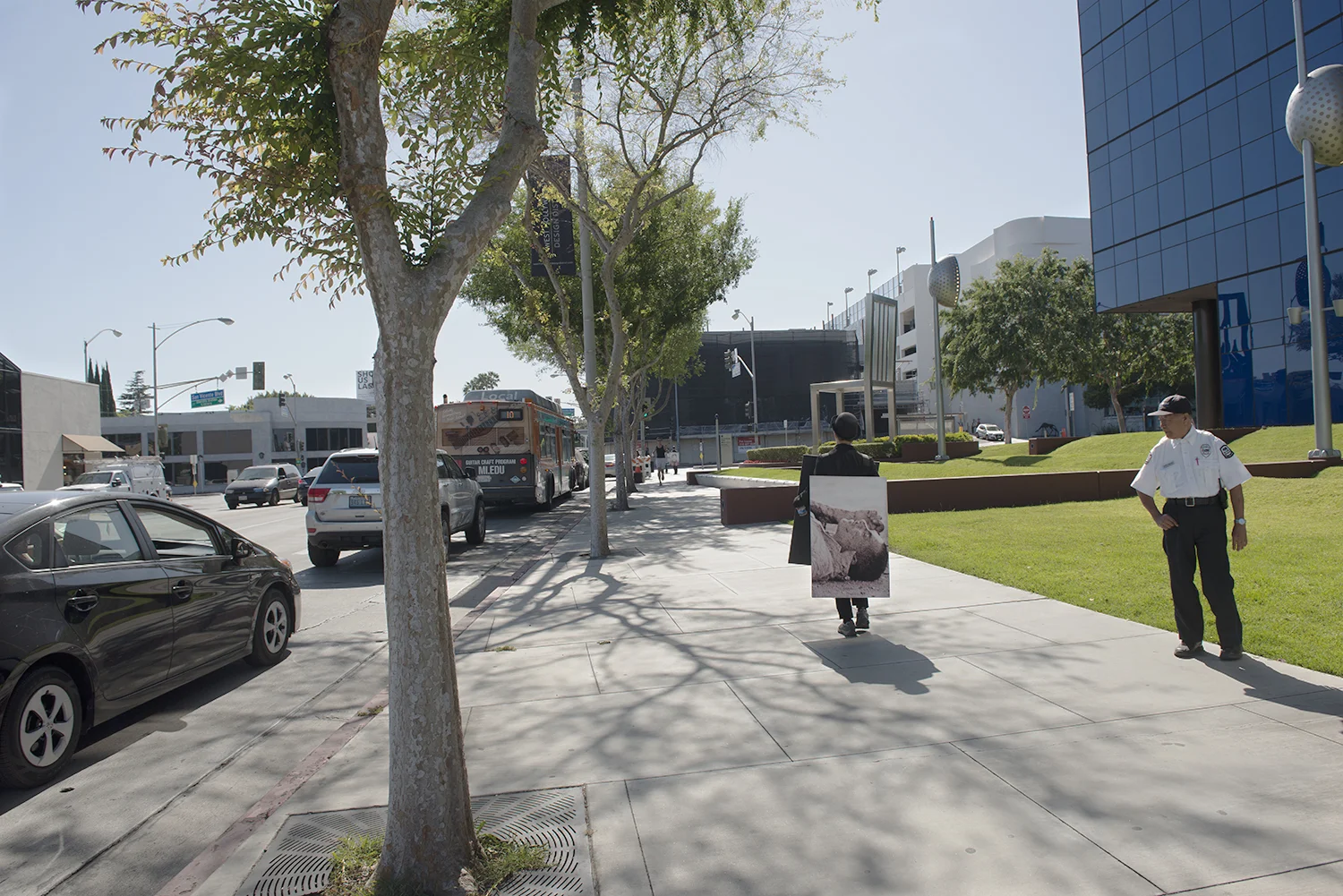 100 Walkers, West Hollywood , a large scale performance piece by Richard Kraft took place on April 18th 2015. One hundred people, each dressed in a dark suit and bowler hat and wearing a sandwich board (with a unique image on both front and back) walked pre-determined routes through the city. The piece began with all one hundred walkers forming a grid in the El Tovar parking lot adjacent to West Hollywood Park. Once all one hundred walkers were in place, the maestra of ceremonies Marjorie Perloff began calling "start phrases" to release one walker at a time at approximately five second intervals. Once the walkers dispersed, they could be seen all over West Hollywood, particularly along all the main thoroughfares: Sunset, Santa Monica, Melrose, Beverly, San Vicente, Doheny, La Cienega, Crescent Heights and Fairfax. During the piece performers remained silent. Interaction with inquisitive passers by was confined to the handing out of a business card. The walk ended when all walkers returned to their starting point at the El Tovar parking lot, standing for one minute to finish their performance. For more images and further information please visit: www.onehundredwalkers.com Photo by Jin Han