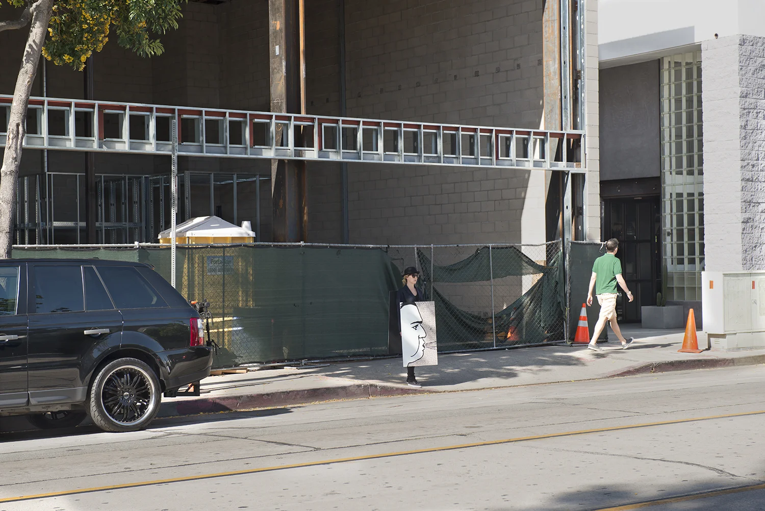 100 Walkers, West Hollywood , a large scale performance piece by Richard Kraft took place on April 18th 2015. One hundred people, each dressed in a dark suit and bowler hat and wearing a sandwich board (with a unique image on both front and back) walked pre-determined routes through the city. The piece began with all one hundred walkers forming a grid in the El Tovar parking lot adjacent to West Hollywood Park. Once all one hundred walkers were in place, the maestra of ceremonies Marjorie Perloff began calling "start phrases" to release one walker at a time at approximately five second intervals. Once the walkers dispersed, they could be seen all over West Hollywood, particularly along all the main thoroughfares: Sunset, Santa Monica, Melrose, Beverly, San Vicente, Doheny, La Cienega, Crescent Heights and Fairfax. During the piece performers remained silent. Interaction with inquisitive passers by was confined to the handing out of a business card. The walk ended when all walkers returned to their starting point at the El Tovar parking lot, standing for one minute to finish their performance. For more images and further information please visit: www.onehundredwalkers.com Photo by Kyle Flath