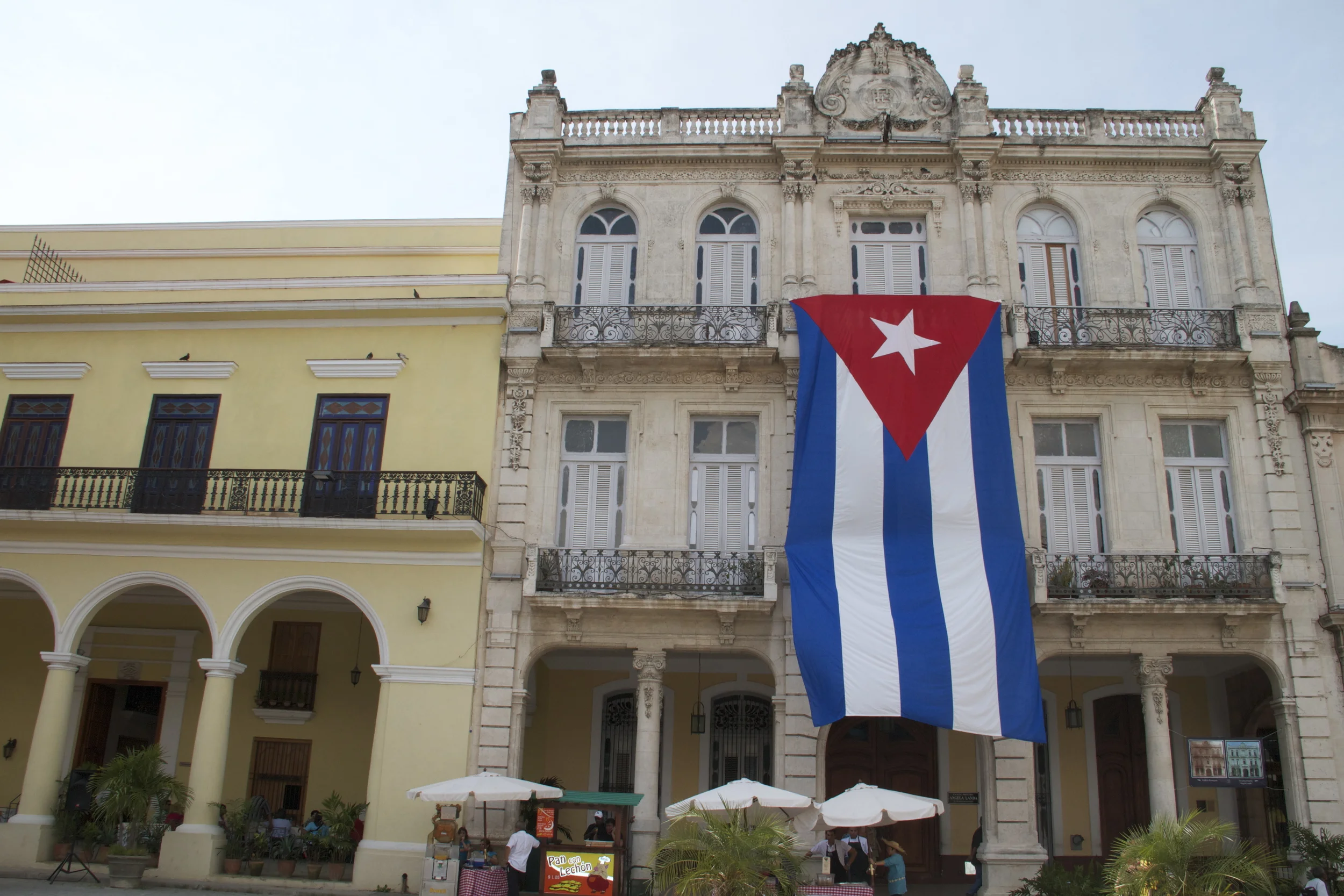 Cuban flag in front of caafe and hotel in Havana