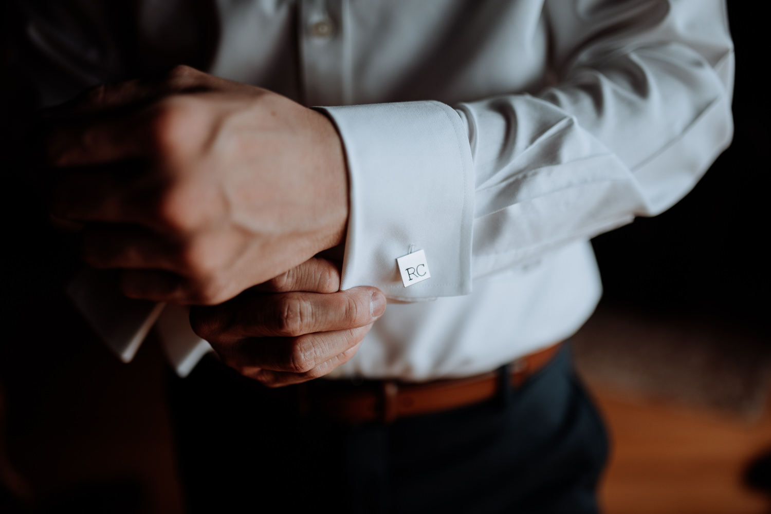 groom fastens monogrammed cufflinks
