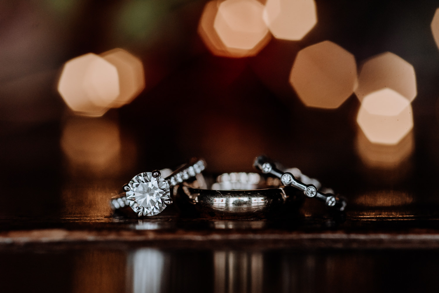 Creative picture of engagement ring and wedding bands at red Maple Vineyard