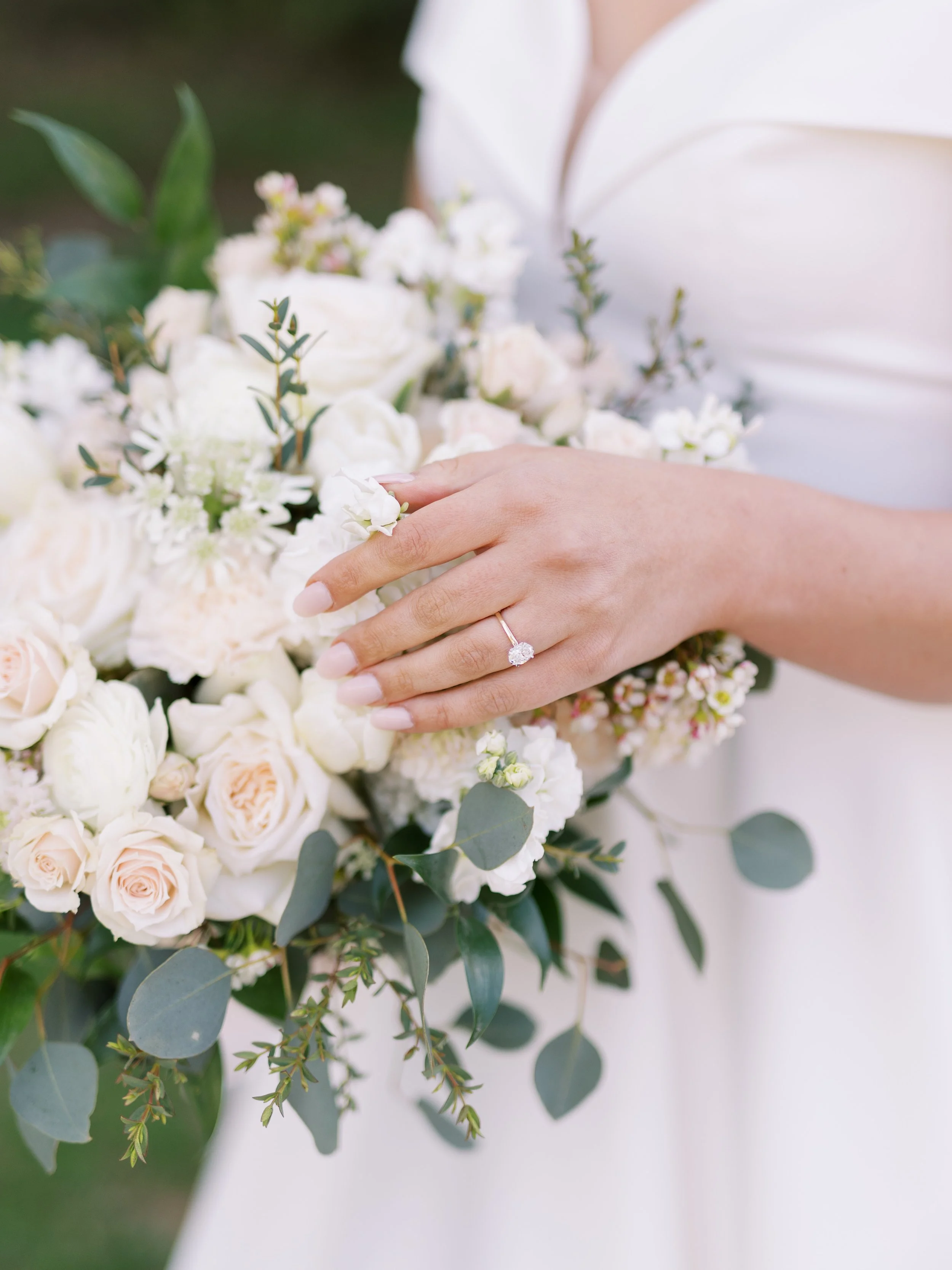 Wedding flowers at St. Catherine’s at Bell Gable, Fayetteville, AR by Rose of Sharon Floral Design Studio. Bridal bouquet designed with just a hint of naturally cascading foliage, white and blush roses, barely blush carnations, white stock, white ran