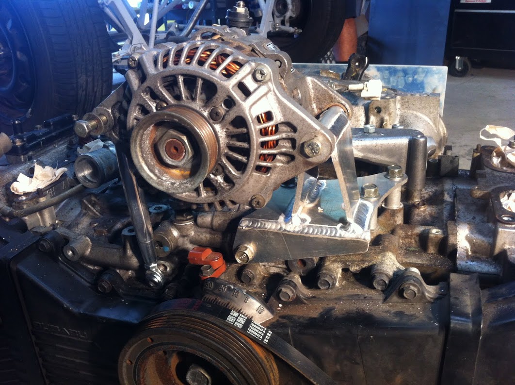 Alternator installed on motor with turnbuckle adjuster.