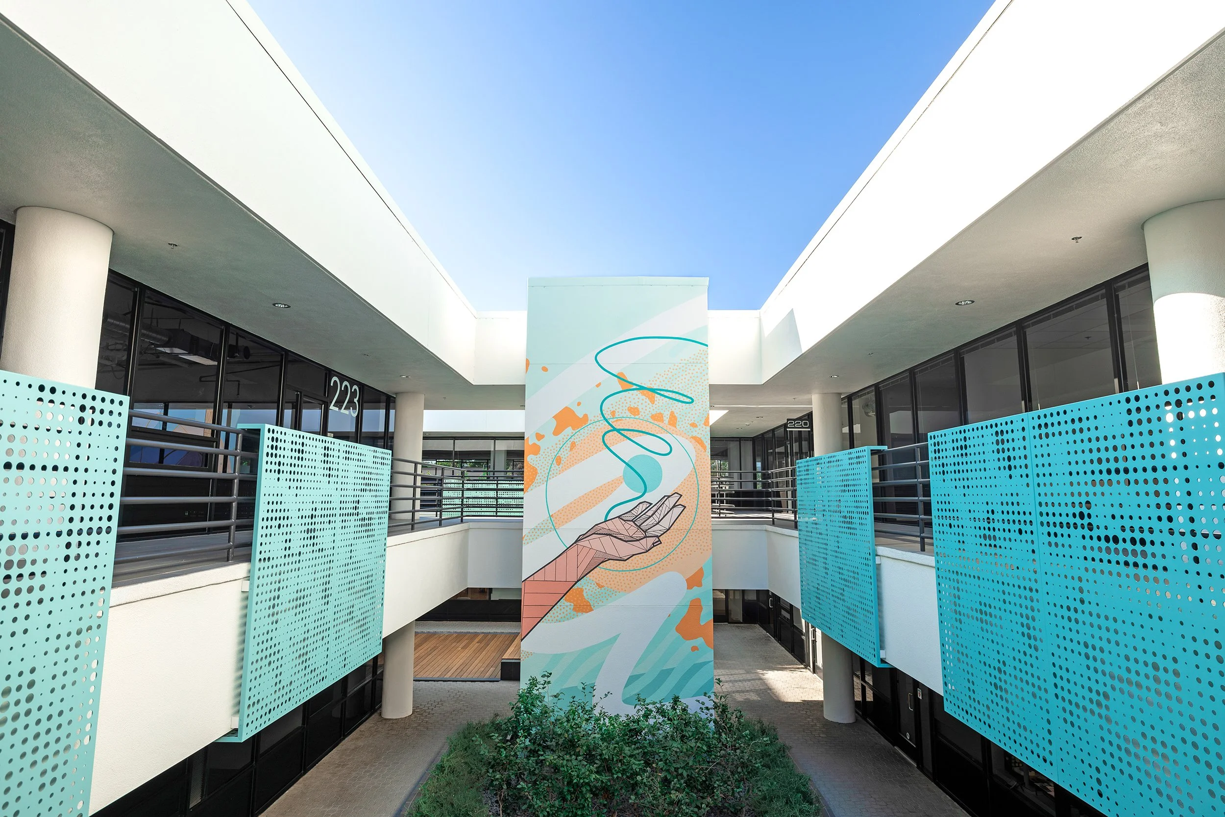 A hand-painted mural by Allison Kunath featuring a pink geometric hand with palm up, interacting with playful abstract shapes and textures in turquoise, orange and white.