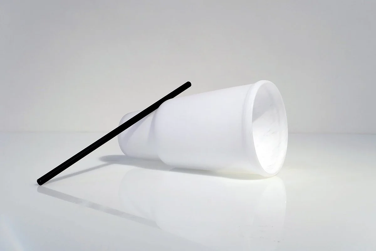 Black straw extending from bottom shoulder of cup_01.jpg