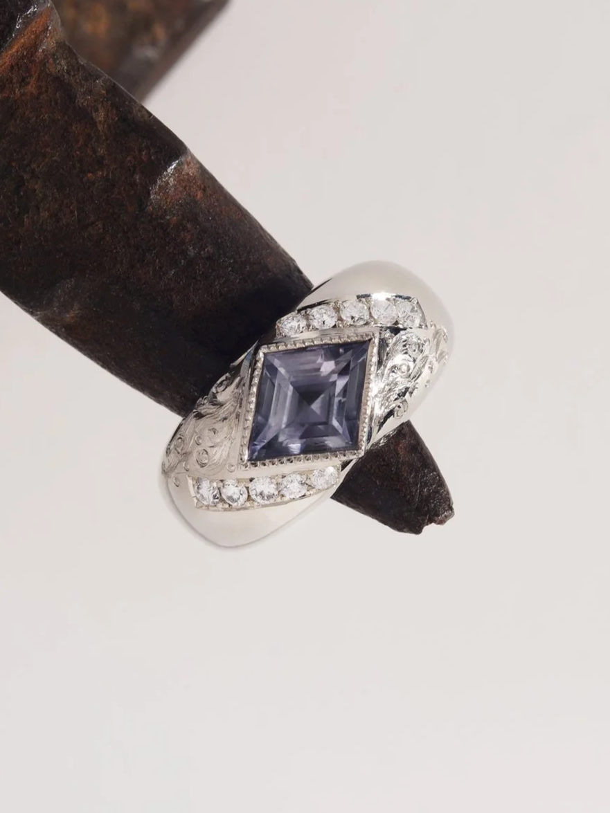 Lozenge cut sapphire, white diamonds and hand engraved waves in white gold