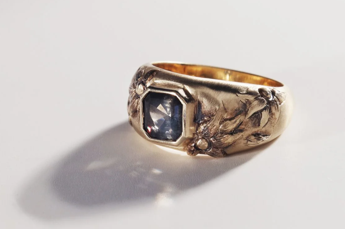 Hand sculpted yellow gold and an asscher cut dark grey sapphire 