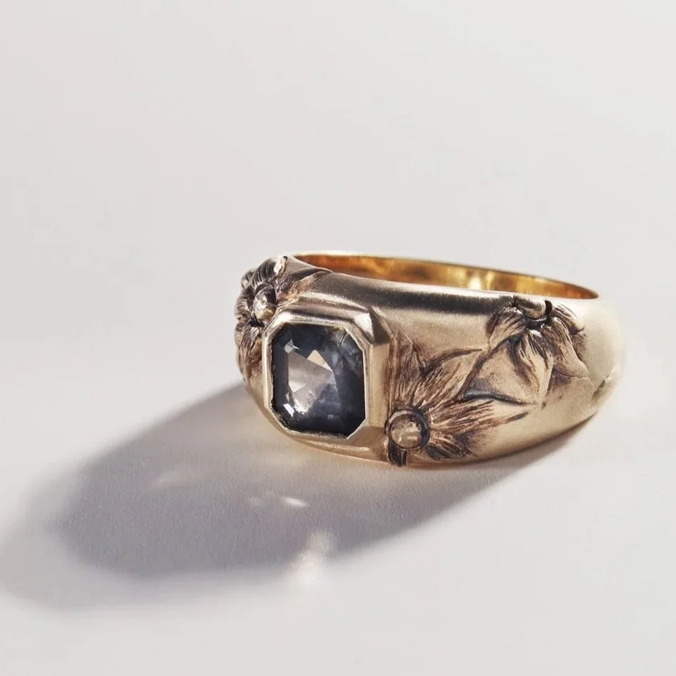 Hand sculpted yellow gold and an asscher cut dark grey sapphire 