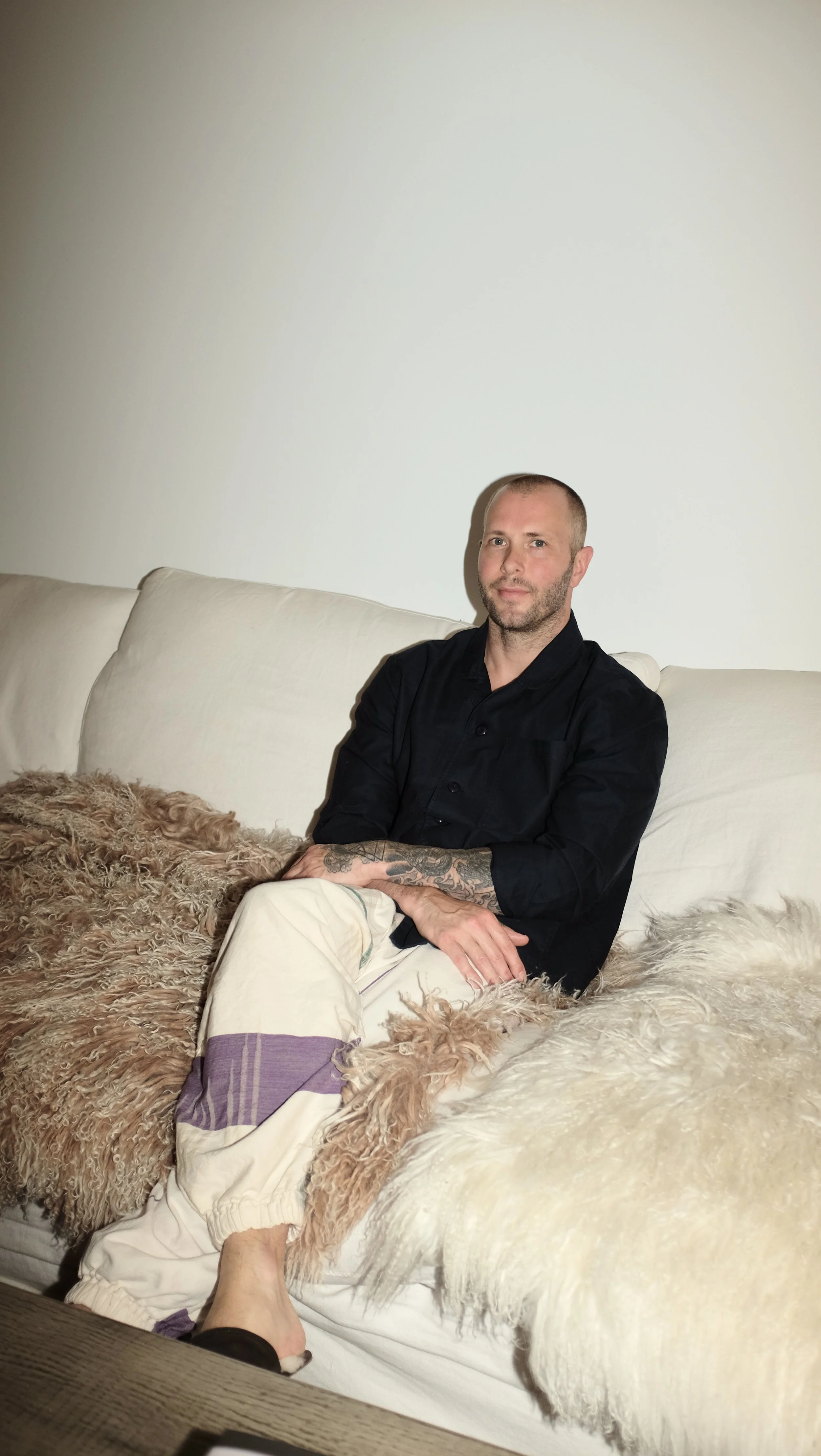 Mike Bagale sitting wearing black chef coat designed by Finery.