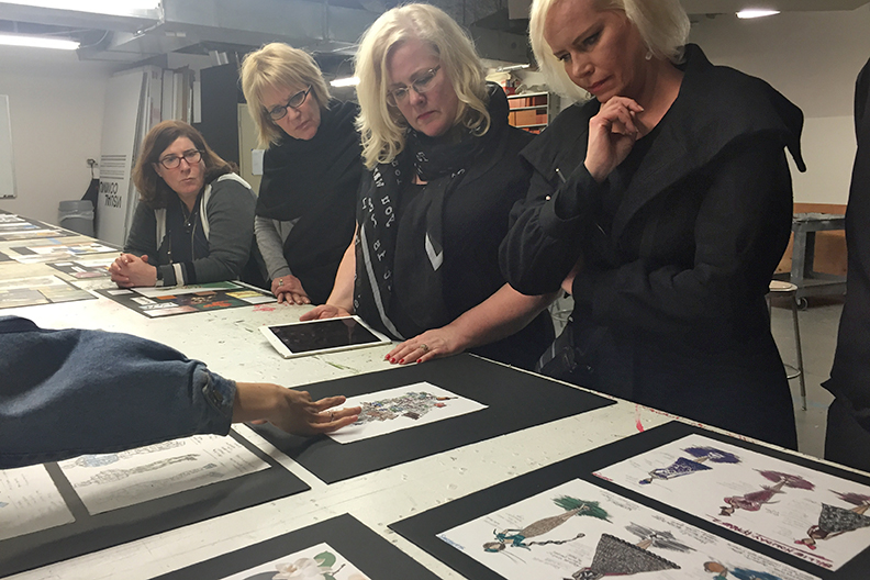 The Macy's Visual Team reviewing student drawings.