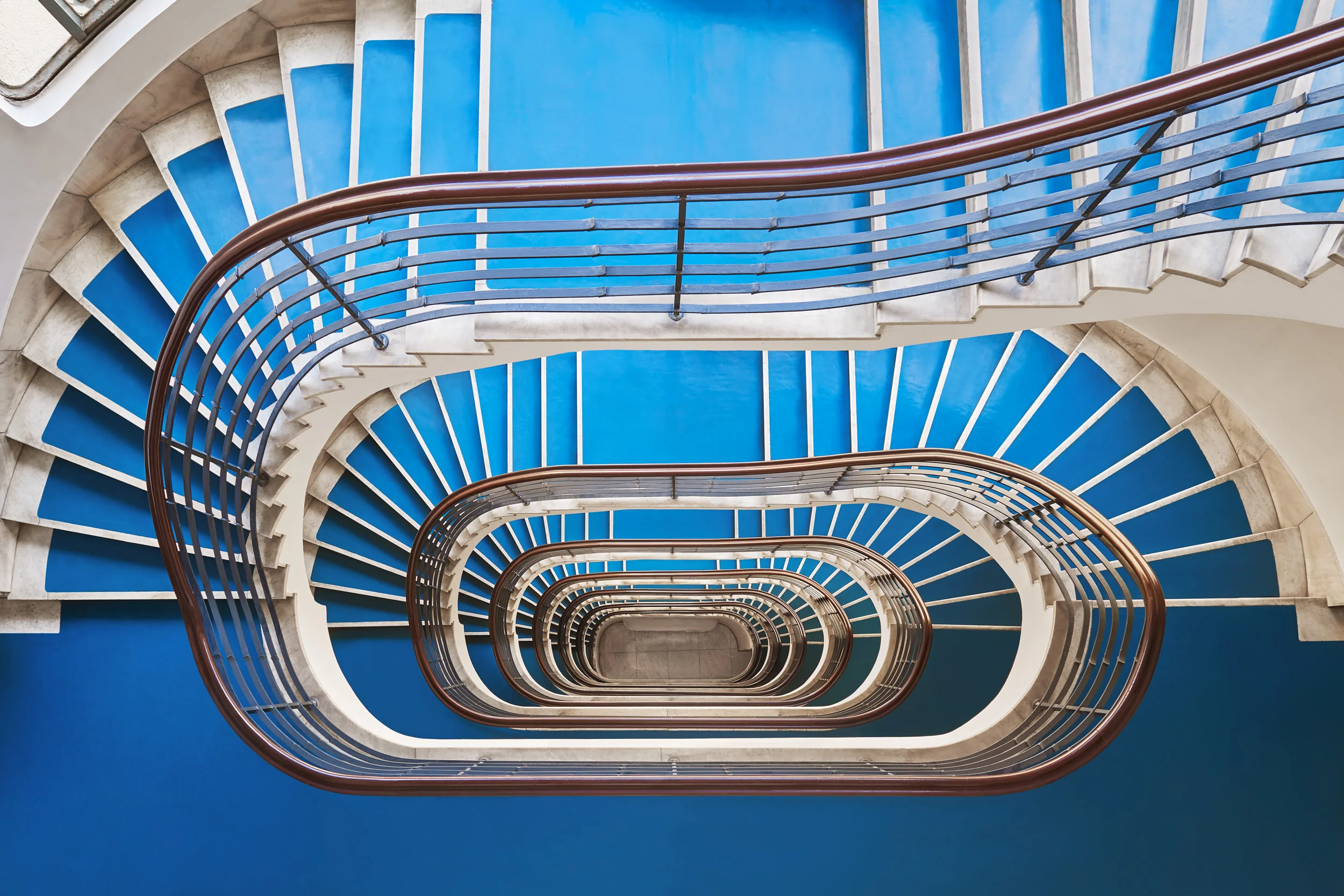TIME MACHINE: BUDAPEST STAIRCASES The staircase in an apartment block is a vertical street, a part public/part public route which is as much about representation as access. Balint Alovits' photos of spiralling Budapest stairs give an impression of infinity, a sense of swirling vertigo but they also underline the architectural invention and thought that was applied to what might otherwise have been purely functional. With thanks to Balint Alovits. http://www.balintalovits.com/ ©Balint Alovits