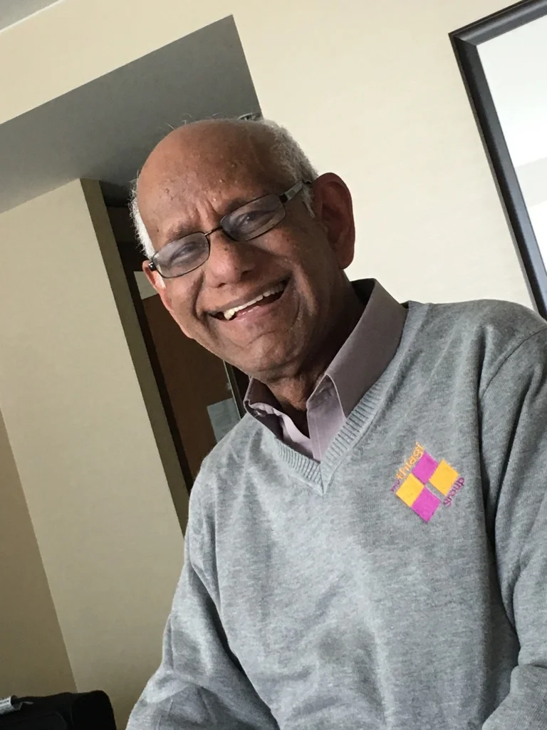 Thiagi in our hotel room wearing our new branded sweater.