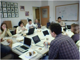 Faculty members working in a group on their laptops.