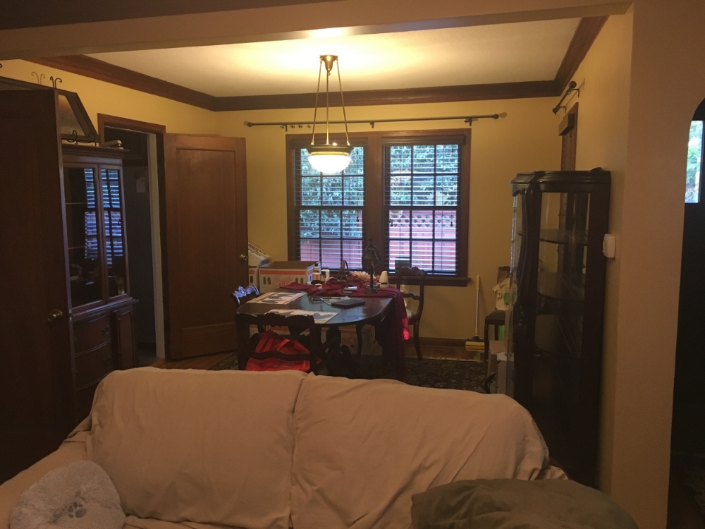 Before: Here in this dining room, it is hard to tell what space it is. There are way too many pieces of large furniture and the doors, being very dark, make the space feel tight. 