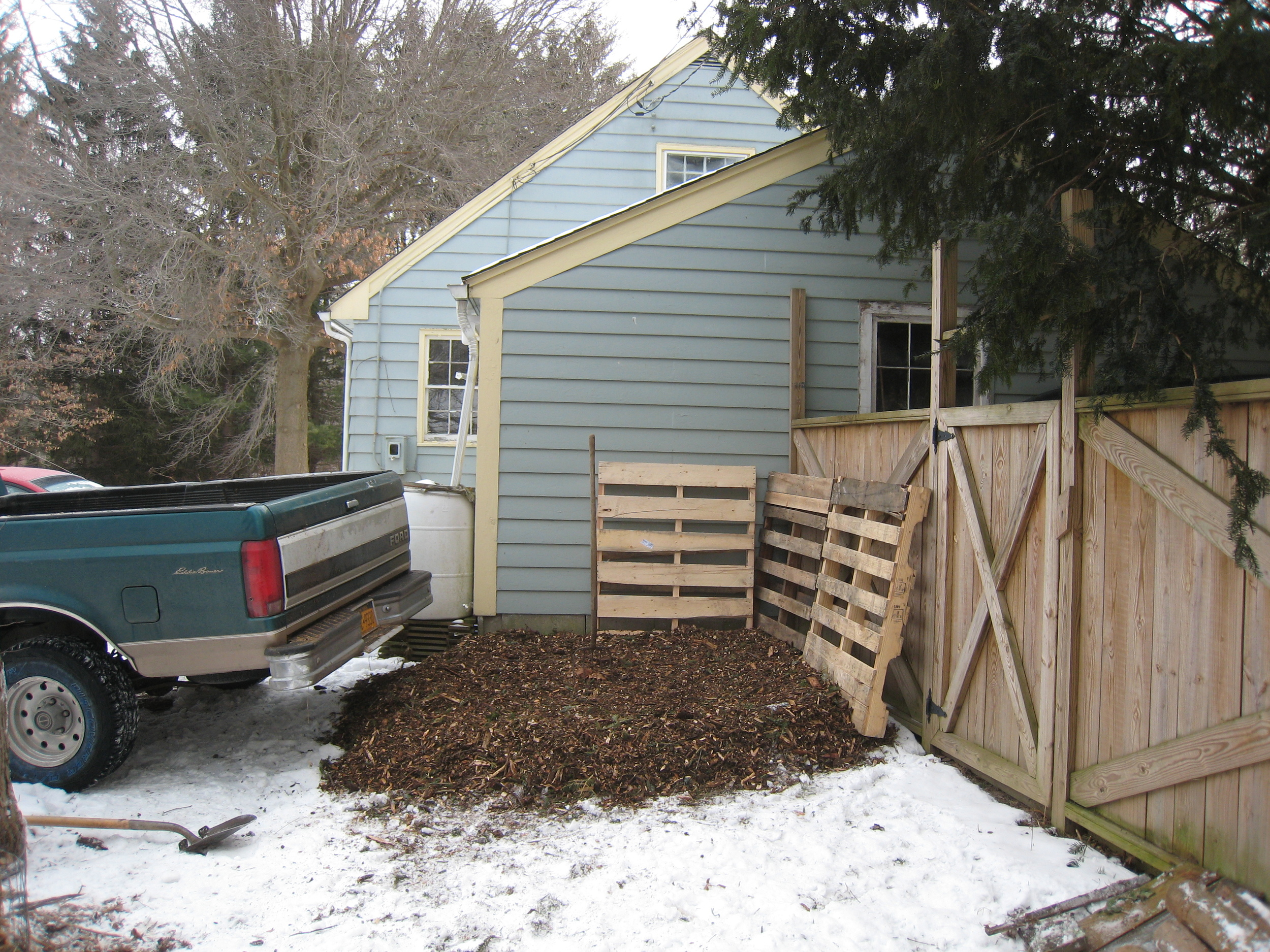 Rough area sketched out with 1/2 truck load aged woodchips as base, leveled and slightly pitched from the garage, and pallets behind to deflect and keep compost off wooden structures... We'll post more pics as we go!