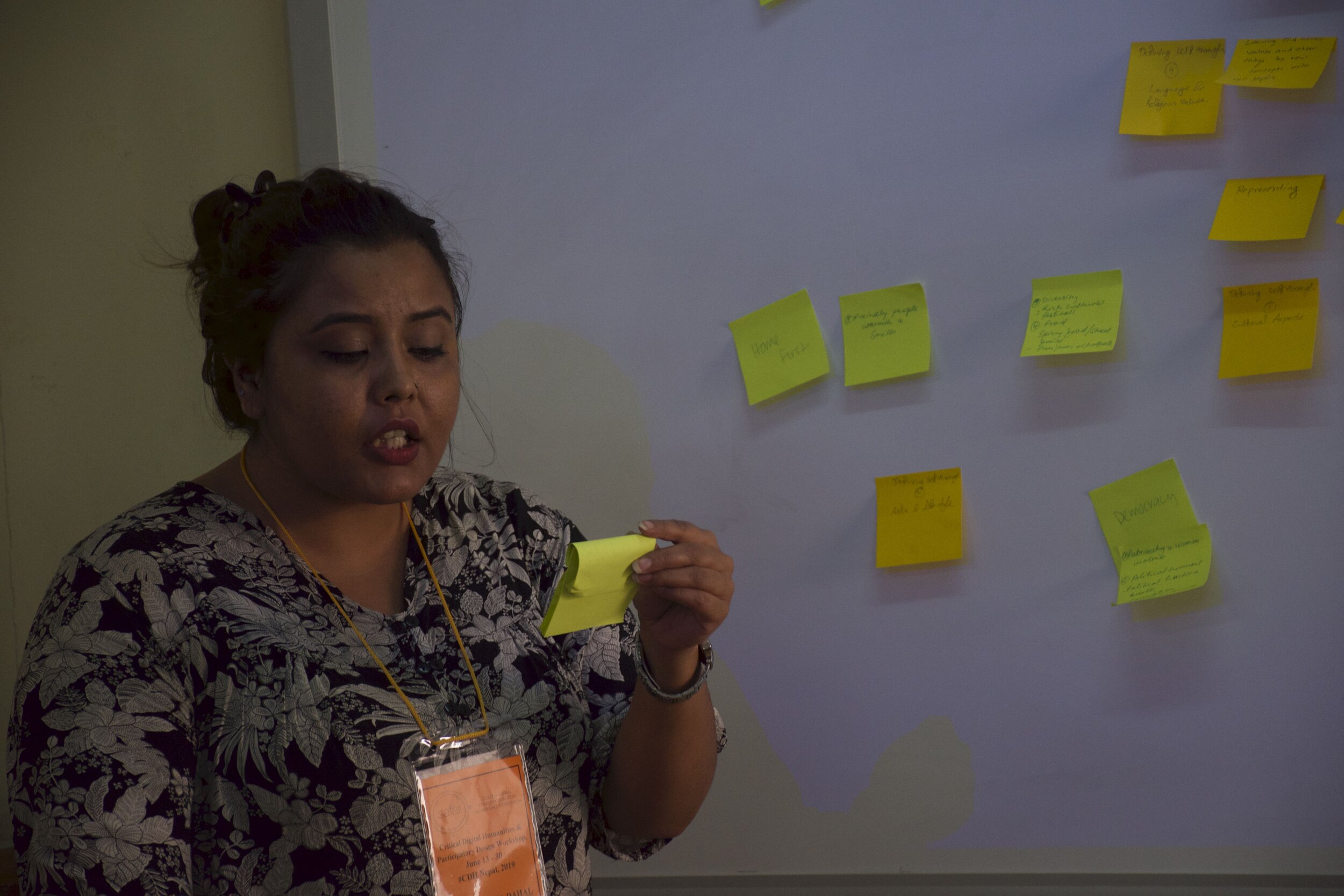 A student reads from a sticky note in front of her class.