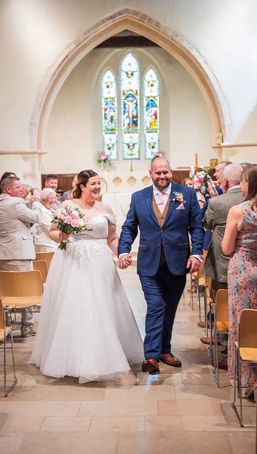 Sussex couple walking down aisle at their wedding at st peter and st paul church in Rustington