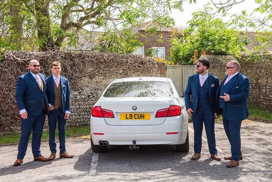 Sussex groom and wedding party posing in wedding suits
