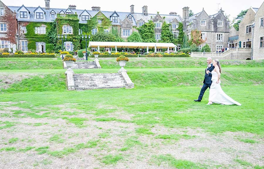 Bride and groom taking a walk at South Lodge Hotel, Horsham, captured naturally by Darren Gritton Photography.