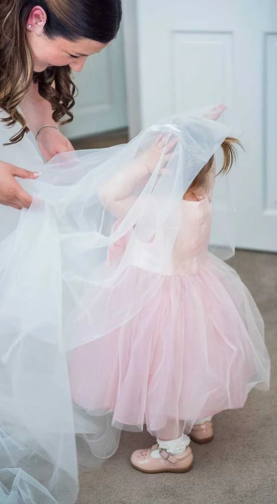 Sussex bride playing with child with her wedding veil