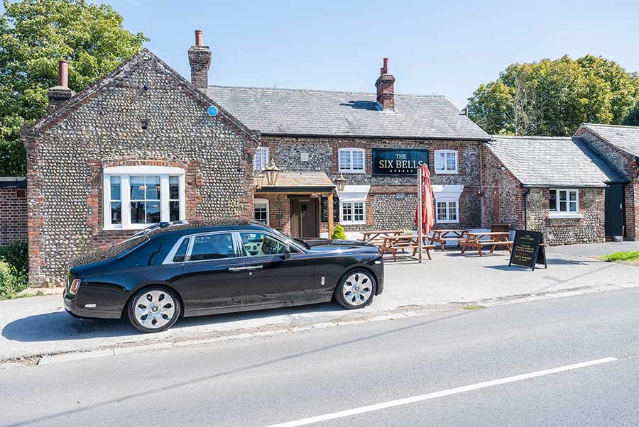 Exterior of The Six Bells pub in Lyminster, West Sussex, showcasing the traditional pub entrance and welcoming atmosphere.
