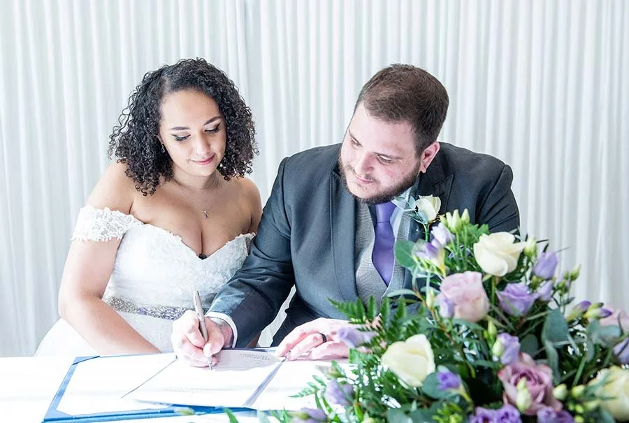 Bride and groom sharing a quiet, intimate moment together at the Chichester Harbour Hotel, signing the marriage certificate.