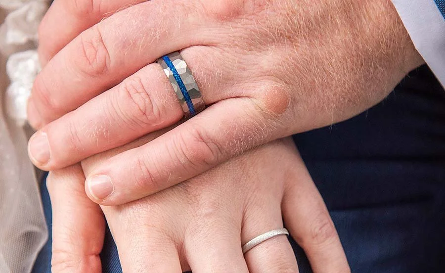 close up of bride and groom's hands showing off wedding rings