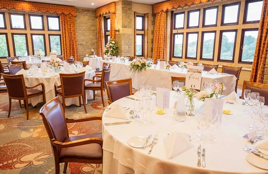 Wedding reception room at South Lodge decorated for the newlyweds, with tables set for guests to celebrate.