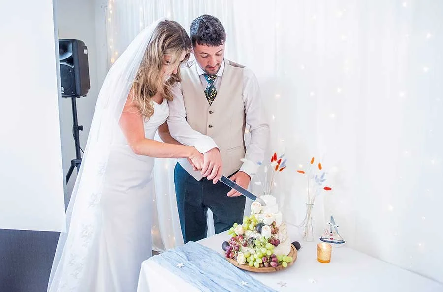 Wedding cake cutting during a reception at Chichester Yacht Club