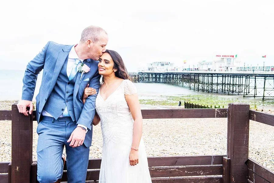Romantic outdoor portrait of bride and groom by Worthing seafront near Worthing Dome.