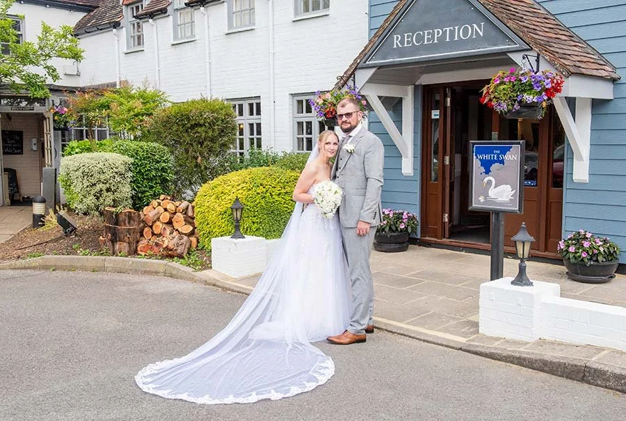 Bride and groom standing at front of The White Swan, Arundel for a photo