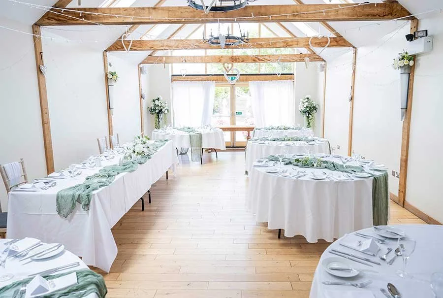 Wedding reception room at Random Hall decorated for the newlyweds, with tables set for guests to celebrate.