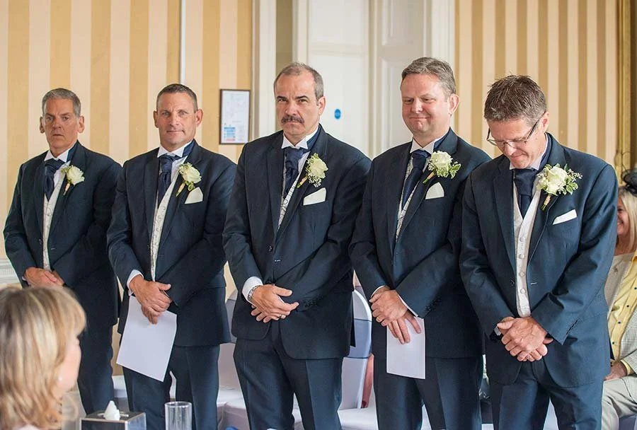 Groom and groomsmen preparing for the wedding at The Norfolk Arms in Arundel, West Sussex, sharing a joyful moment before the ceremony.