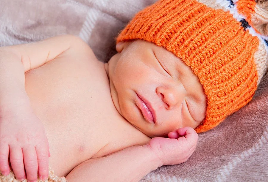 Newborn baby wearing a fox outfit during a styled studio photography session in our Littlehampton studio