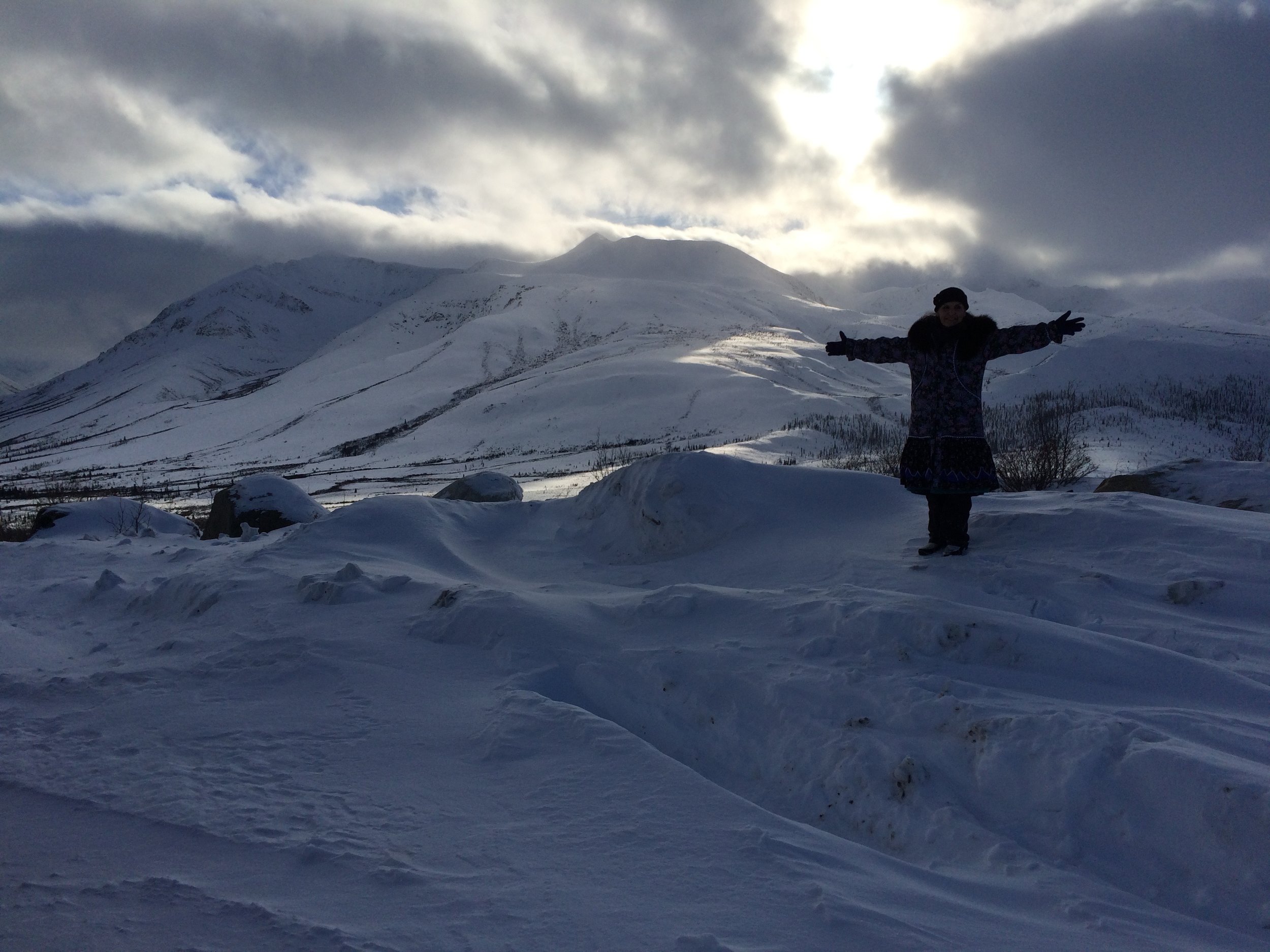 Louise in the Yukon with a big bear in the clouds.