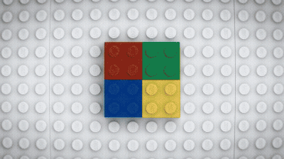 Close-up of four LEGO bricks arranged to form a square, with red, green, blue, and yellow bricks on a white LEGO baseplate background.